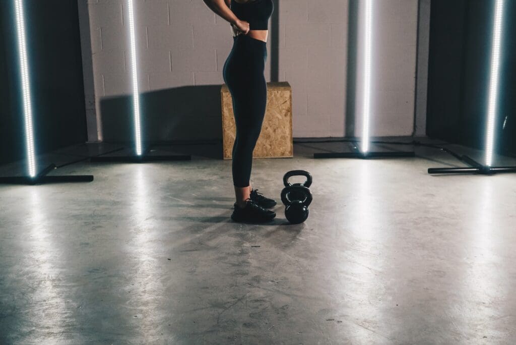 femme avec des deux kettlebell en face d'elle