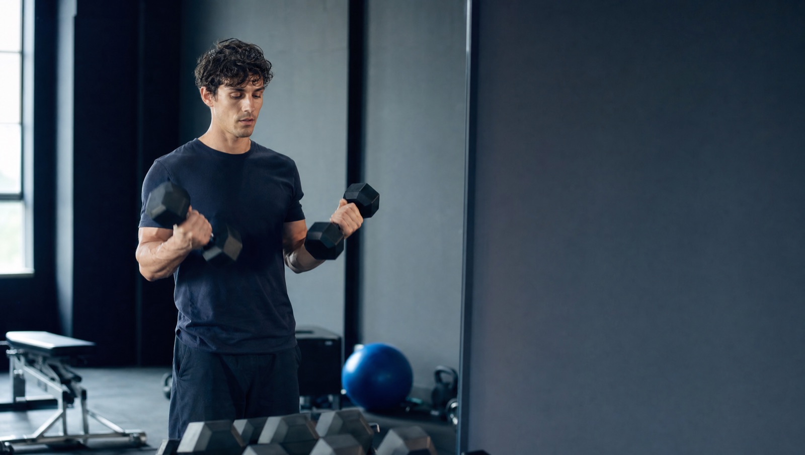 Haltères légers face au miroir, programme de musculation débutant